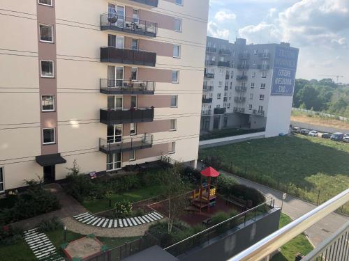 een appartementencomplex met een speeltuin ervoor bij Apartament Winorośli in Warschau