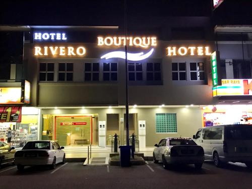 um hotel com carros estacionados fora dele à noite em RIVERO BOUTIQUE HOTEL Seremban 2 em Seremban