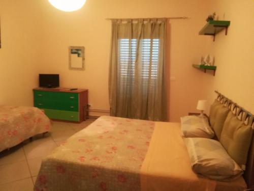 a bedroom with a bed and a dresser and a window at B&B Il Gabbiano in Reggio Calabria