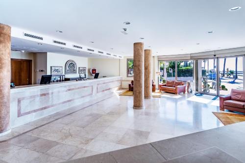 a lobby with a bar in a building at Sunway Playa Golf & Spa Sitges in Sitges