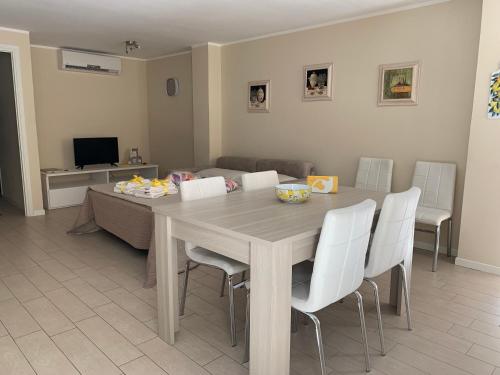 a dining room with a table and white chairs at Al Lago da Lilly in Gargnano