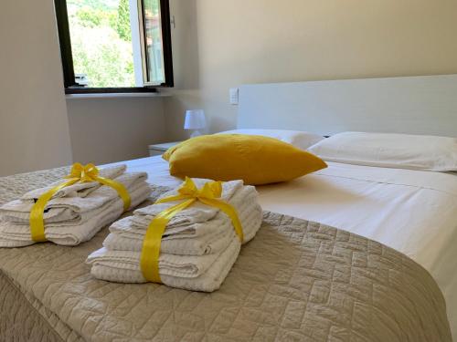 a bedroom with two towels and a yellow pillow on a bed at Al Lago da Lilly in Gargnano