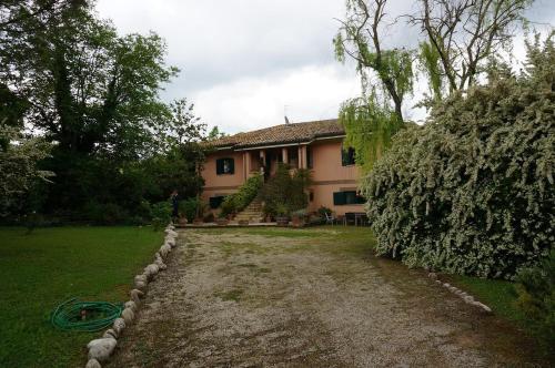 a house with a gravel road in front of it at Agriturismo La CasinaRosa in Loreto Aprutino