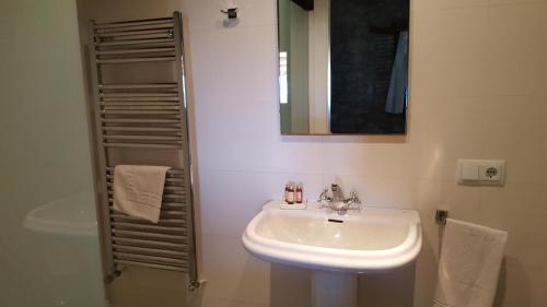 y baño con lavabo, espejo y ducha. en Casa Baluard de Ferreres, en Olvan