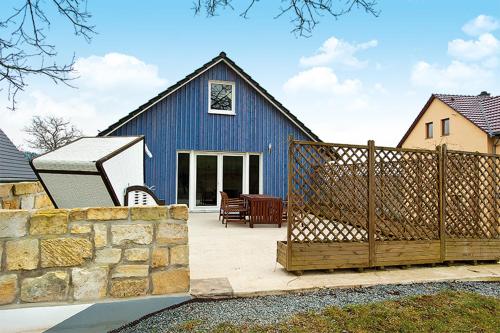 a blue house with a fence in front of it at Bergoase Panorama-Apartments in Kirnitzschtal