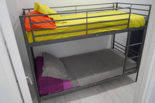 a bunk bed with different colored sheets on it at Coworking Studio in Las Palmas de Gran Canaria