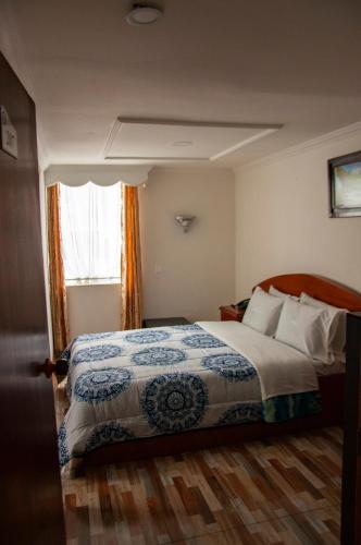 a hotel room with a bed and a window at La Gran Fortaleza B&B in Bogotá