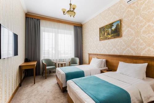 pokój hotelowy z 2 łóżkami i stołem w obiekcie Zolotaya 7 Hotel Domodedovo w mieście Domodiedowo