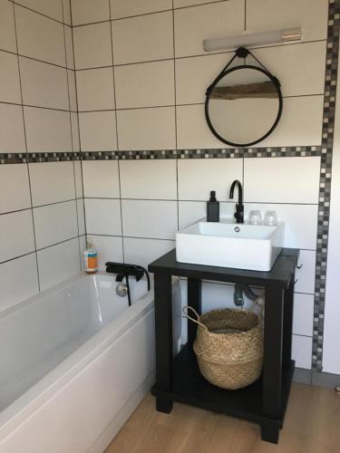 ein Badezimmer mit einem Waschbecken und einer Badewanne in der Unterkunft La Ferme des Potets in Fresse