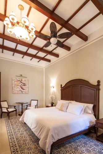 a bedroom with a large bed with a ceiling fan at Casa Tavera- Adults Only in Mérida