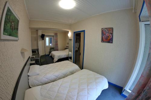 a hotel room with two beds in a room at Hotel De l'Europe in Meyrueis
