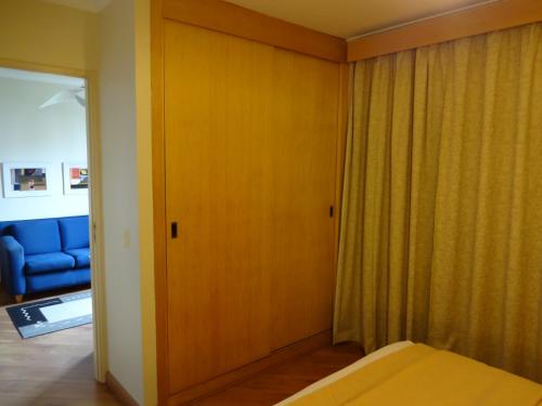 a room with a bed and a sliding door at Residencial Bella Vista Suites in Sao Paulo