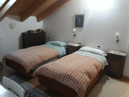 two beds sitting next to each other in a bedroom at Aprt Val di Fiemme - Molina in Castello di Fiemme
