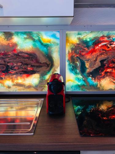a drawer with three paintings on the fronts of a refrigerator at Atelier Lomani in Vienna