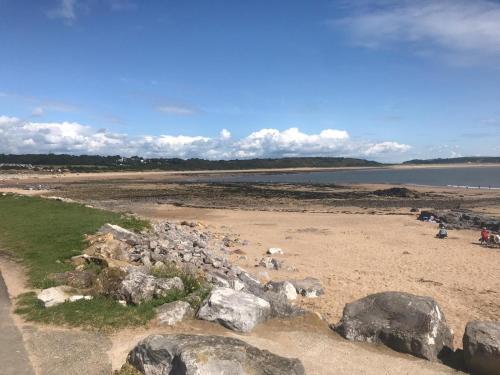 a beach with rocks and a body of water at Brambles 66 -Static Holiday Caravan, Porthcawl in Newton