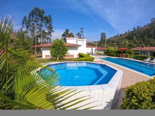 an image of a swimming pool in front of a house at FINCA EL RECUERDO in Gachetá