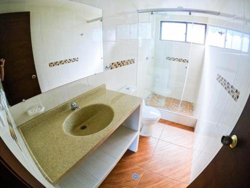a bathroom with a sink and a shower and a toilet at FINCA EL RECUERDO in Gachetá