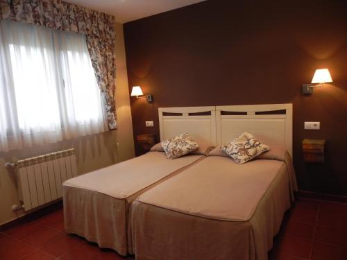 a bedroom with a bed with two pillows on it at Hospederia Los Pinos in Llanes
