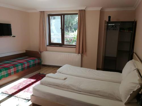 a living room with two beds and a window at Слънчевата къща in Kovachevitsa