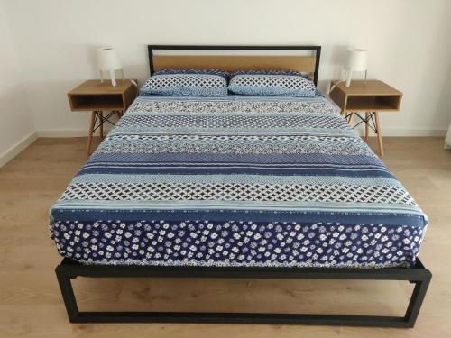 a bed in a room with two nightstands and two tables at Casa Irene in Aveiro