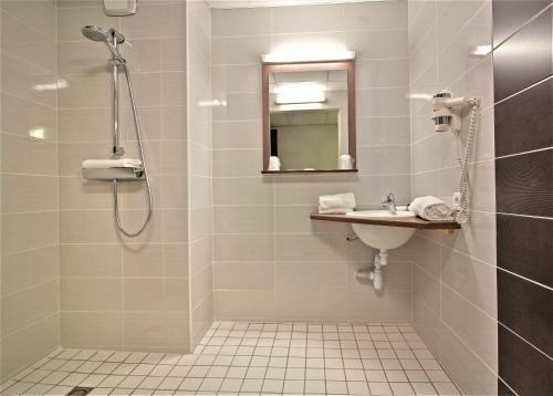 a bathroom with a shower and a sink at Ekho Hotel Grenoble Nord Saint Egrève in Saint-Égrève