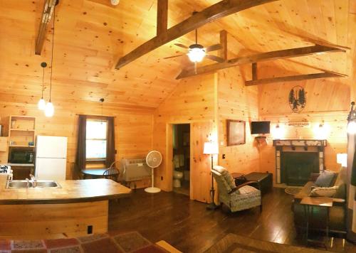 a kitchen and living room of a wooden cabin at The Wilderness Inn: Chalets in Wilmington