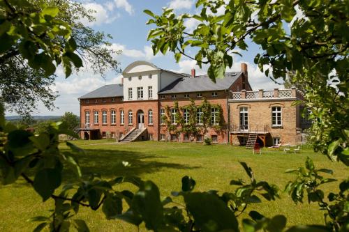 a large brick building on a grass field at Gut Pohnstorf in Alt Sührkow