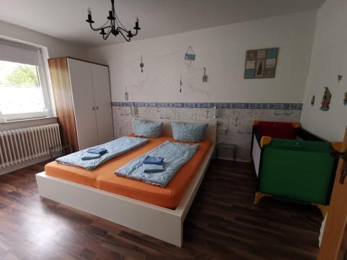 ヴィルヘルムスハーフェンにあるFerienwohnung Wattenmeer mit E-Bike Verleihのベッドと椅子のある寝室
