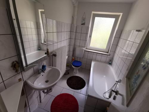 a white bathroom with a sink and a toilet at Ferienwohnung Wattenmeer mit E-Bike Verleih in Wilhelmshaven