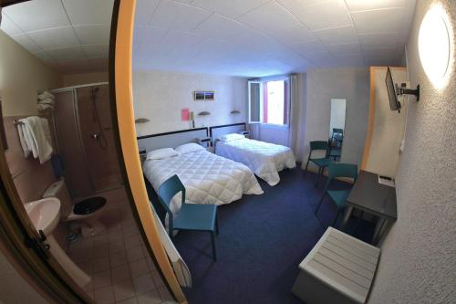 a hotel room with a bed and a bathroom at Hotel De l'Europe in Meyrueis