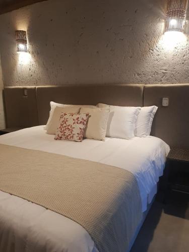 a large bed with white sheets and pillows at Pousada Aldeia da Serra in Palmas