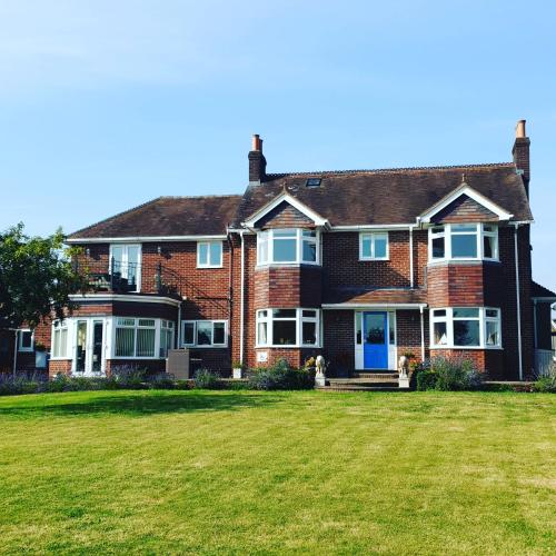 a large brick house with a large grass yard at The Moorhead Bed & Breakfast in Wem