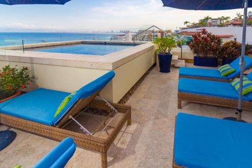 a balcony with chairs and a swimming pool at V Azul Vallarta - Luxury Vacation Rental Adults Only in Puerto Vallarta