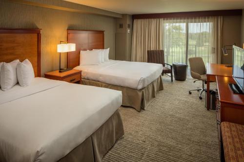 a hotel room with two beds and a desk at Eaglewood Resort & Spa in Itasca