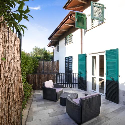 a patio with green shutters on a white house at Albergo Serena in Lerici