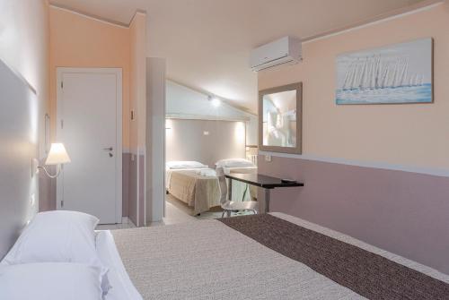 a hotel room with two beds and a mirror at Albergo Serena in Lerici