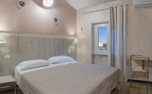 a bedroom with a white bed and a window at Albergo Serena in Lerici