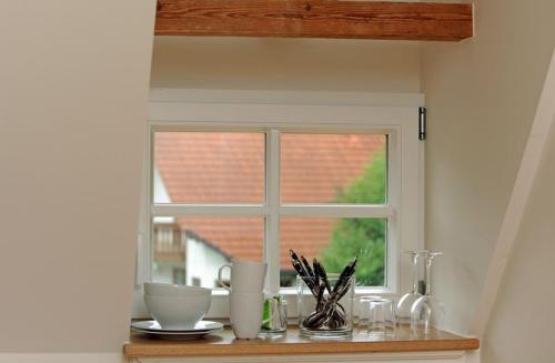 a window in a kitchen with a table with dishes at Gasthaus Schwanen & Villa Pfarrhus in Stühlingen