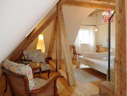 a bedroom with a bed and chairs in a room at Gasthaus Schwanen & Villa Pfarrhus in Stühlingen