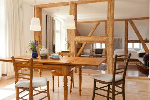 a dining room with a wooden table and chairs at Gut Pohnstorf in Alt Sührkow