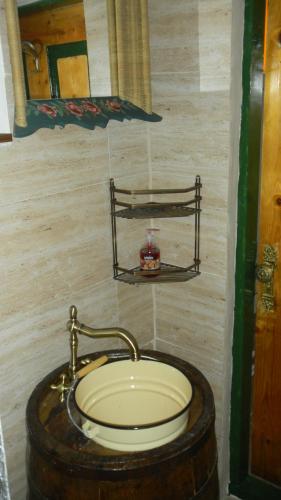 baño con lavabo y barril de madera en Casa Cezara en Silvaşu de Jos