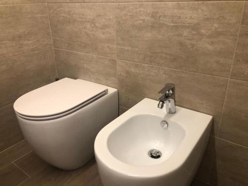 a bathroom with a white toilet and a sink at Ibisco Affittacamere in Iesi
