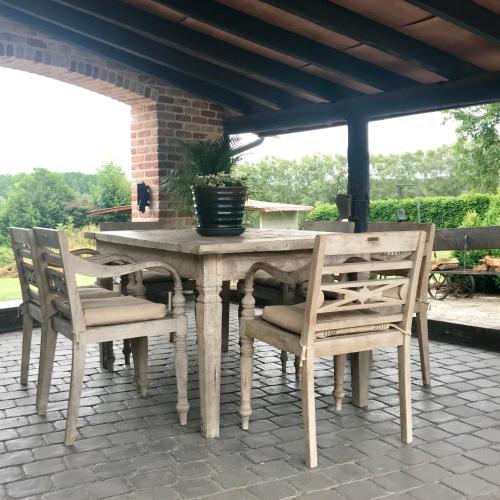 a wooden table and chairs on a patio at Hof Leskensdaele Deluxe in Geraardsbergen