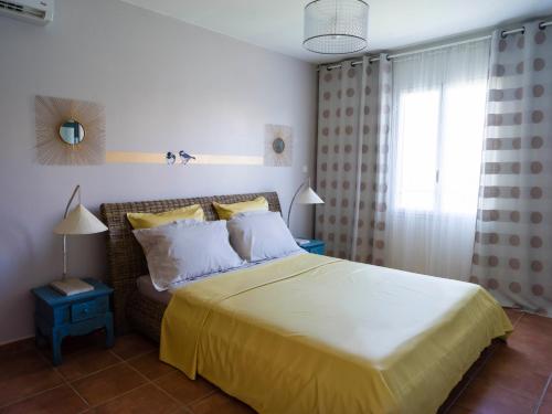 ein Schlafzimmer mit einem großen Bett mit einer gelben Decke in der Unterkunft POP'S APPARTEMENTS RESIDENCE MARISOL au bord de la mer in Le Gosier