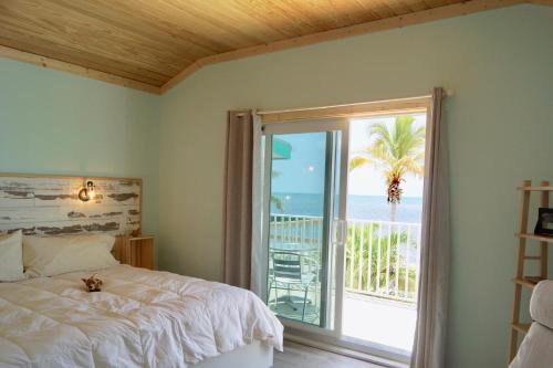 a bedroom with a bed and a window with a view of the ocean at Deer Run on the Atlantic in Big Pine Key