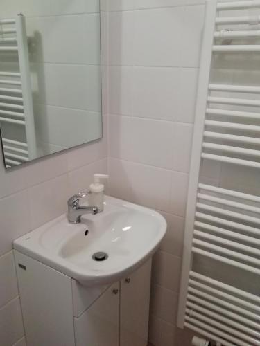 a bathroom with a white sink and a mirror at Apartmán Matylda in Jáchymov