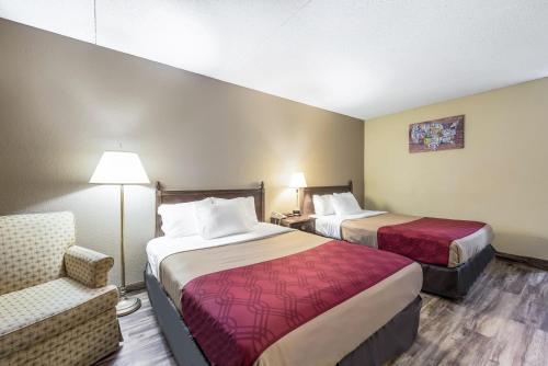 a hotel room with two beds and a chair at Econo Lodge in Albert Lea