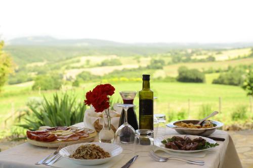 a table with plates of food and a bottle of wine at Cerqueti agriturismo in Baschi