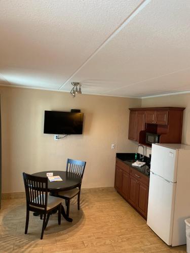 a kitchen with a table and chairs and a refrigerator at Inn on the Gulf in Hudson