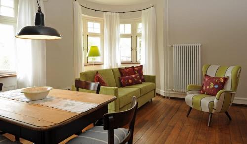 a living room with a green couch and a table at Gasthaus Schwanen & Villa Pfarrhus in Stühlingen